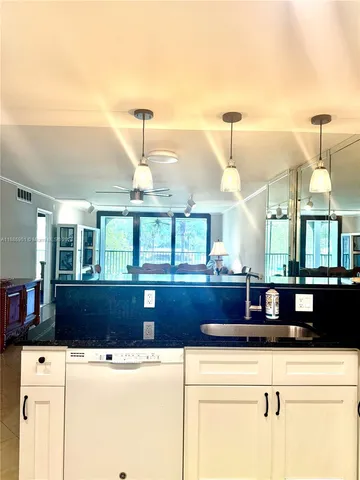 a kitchen with stainless steel appliances a refrigerator a stove a sink and white cabinets