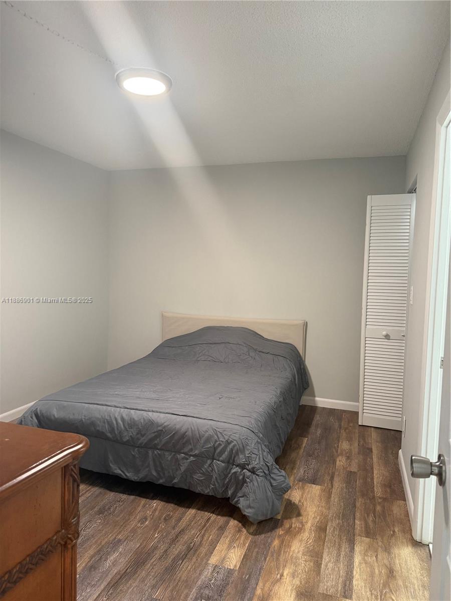 1627 Riverview Road, Unit 212 Deerfield Beach, FL 33441 - Photo 8 of 27 a bedroom with a bed and wooden floor