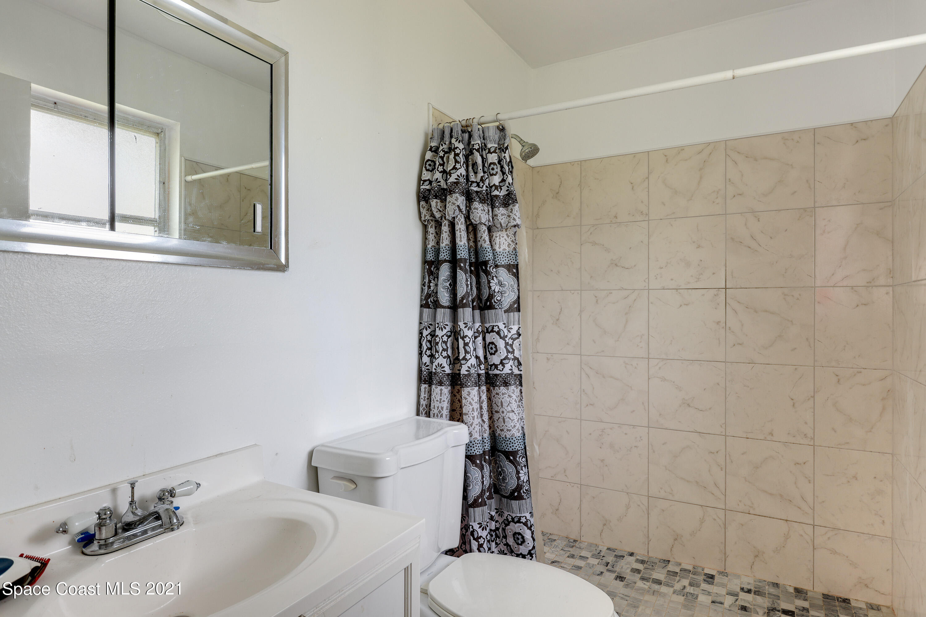 2710 King Richard Road Melbourne, FL 32935 - Photo 13 of 17 a bathroom with a sink toilet and shower