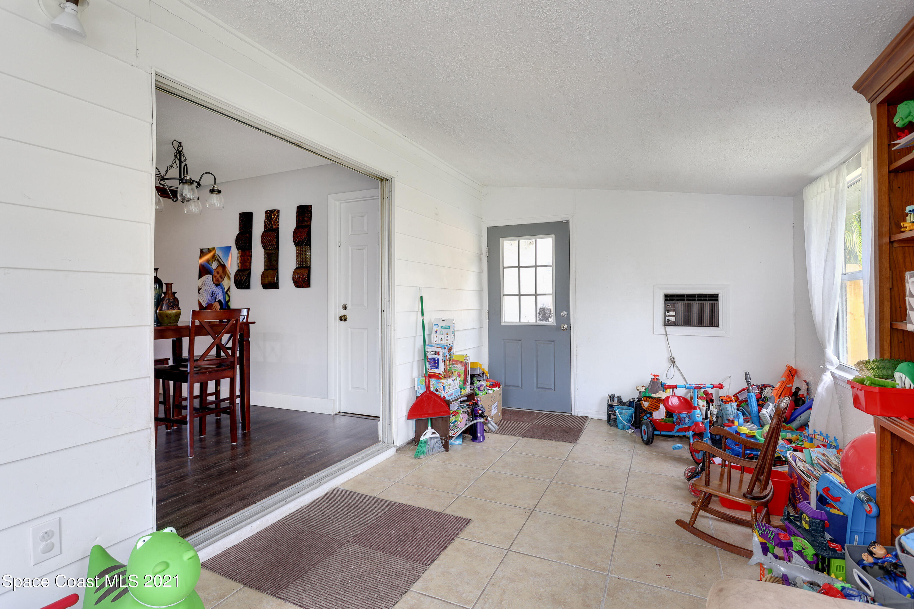 2710 King Richard Road Melbourne, FL 32935 - Photo 9 of 17 wooden floor to ceiling window and a couch