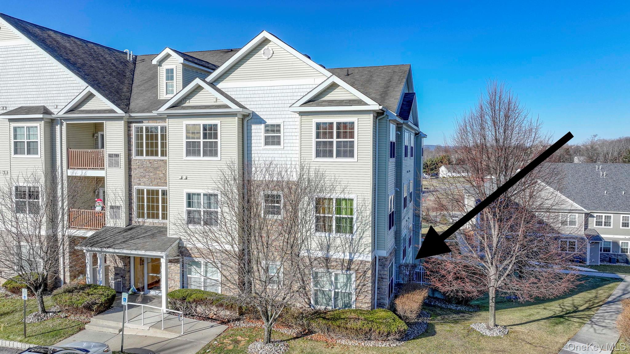 View of front of home featuring roof with shingles and a balcony
