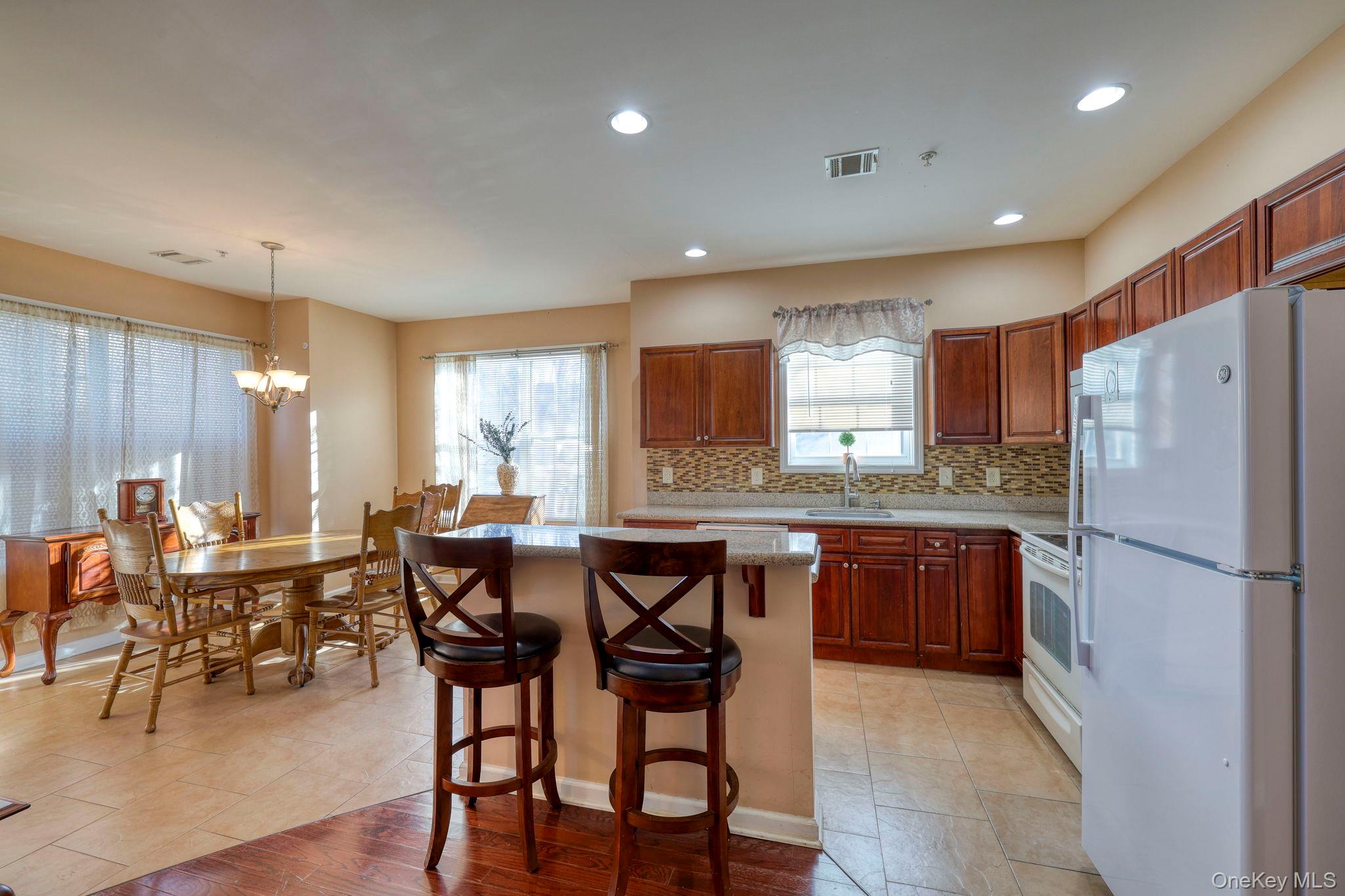 927 Tower Ridge Circle Middletown, NY 10941 - Photo 12 of 36 Kitchen featuring white appliances, pendant lighting, decorative backsplash, a breakfast bar area, and a kitchen island