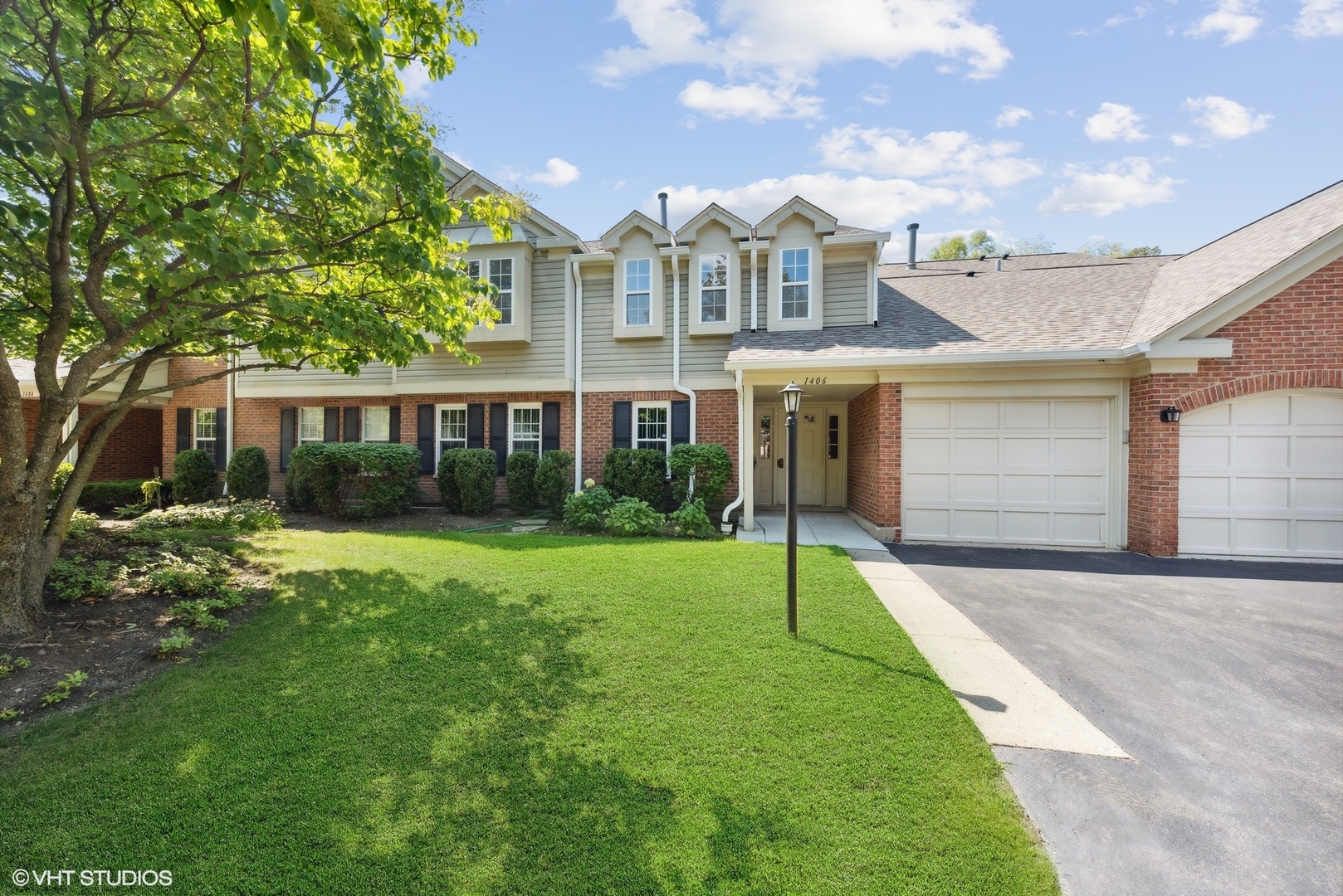 1406 Aldgate Court, Unit D1 Wheeling, IL 60090 - Photo 1 of 16 a view of a house next to a big yard and large trees