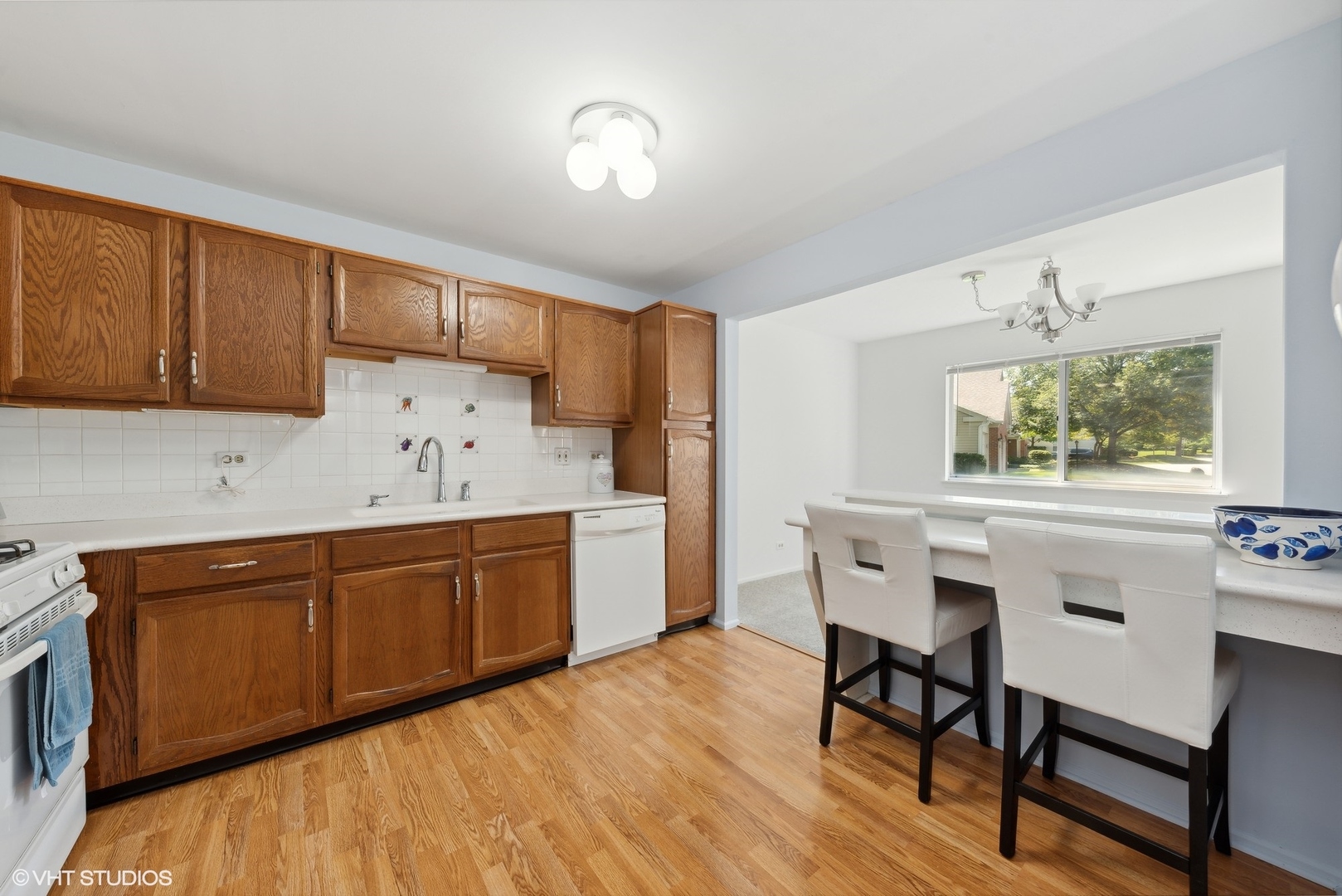 1406 Aldgate Court, Unit D1 Wheeling, IL 60090 - Photo 7 of 16 a kitchen with granite countertop a sink cabinets and window