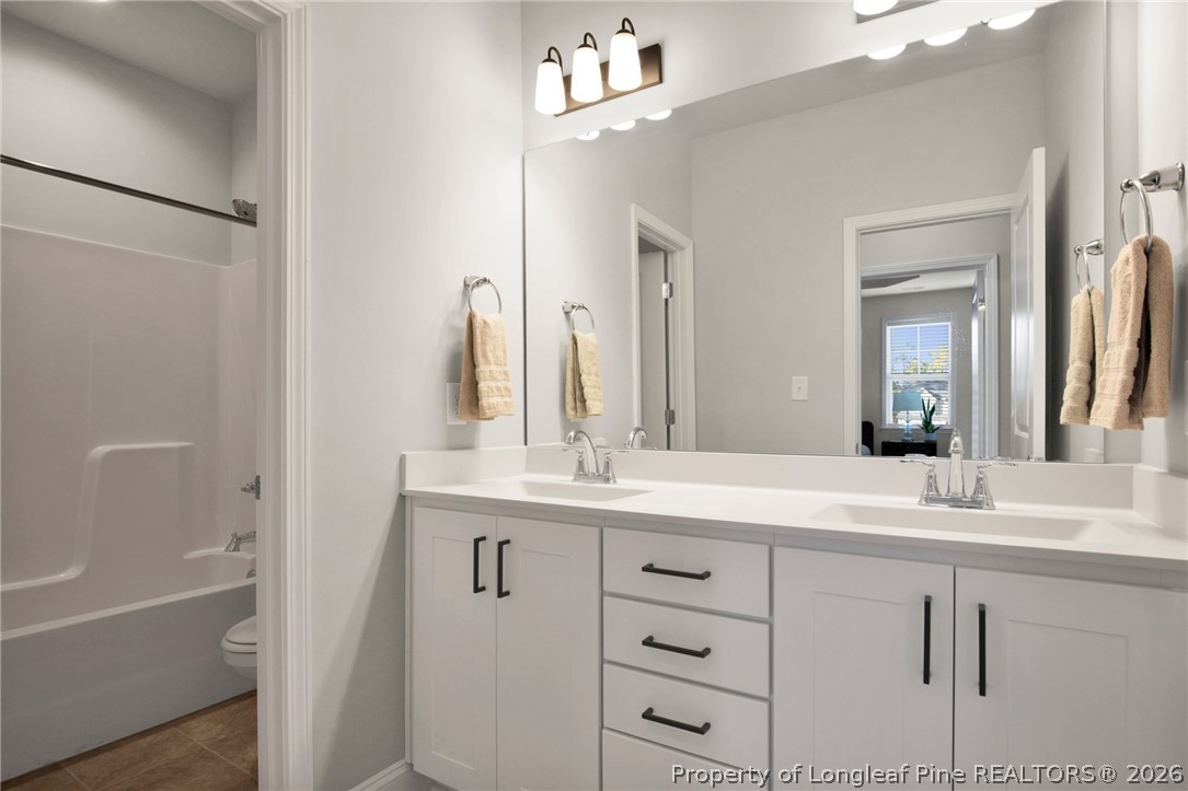 224 Timber Skip Drive Spring Lake, NC 28390 - Photo 21 of 30 a bathroom with a sink vanity tub and a mirror