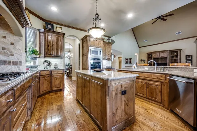 a kitchen with stainless steel appliances granite countertop a stove and cabinets