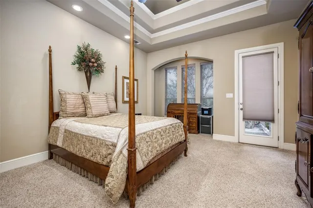 a spacious bedroom with a large bed and a chandelier