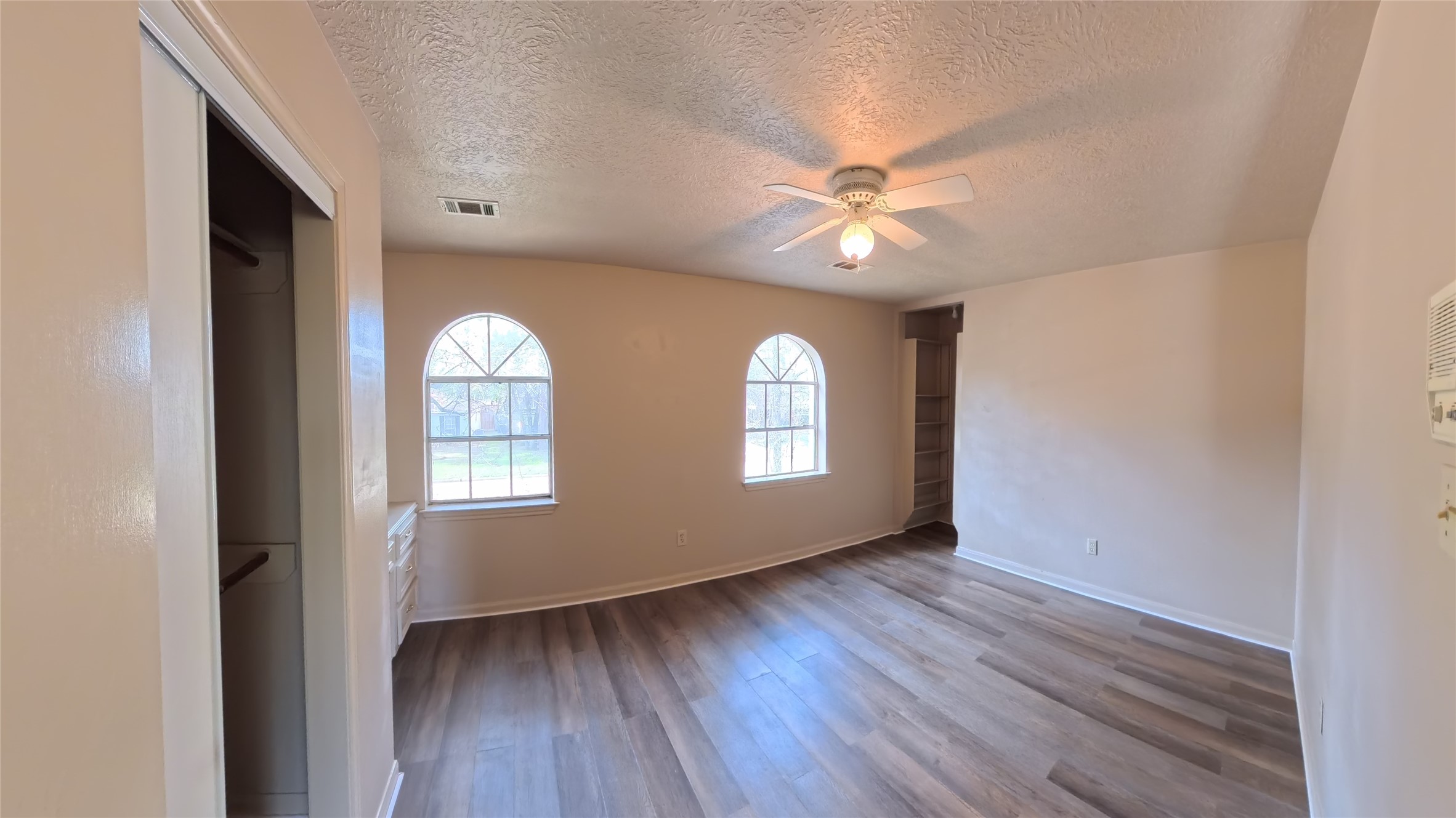 7711 Kleingreen Lane Spring, TX 77379 - Photo 12 of 14 an empty room with wooden floor fan and windows