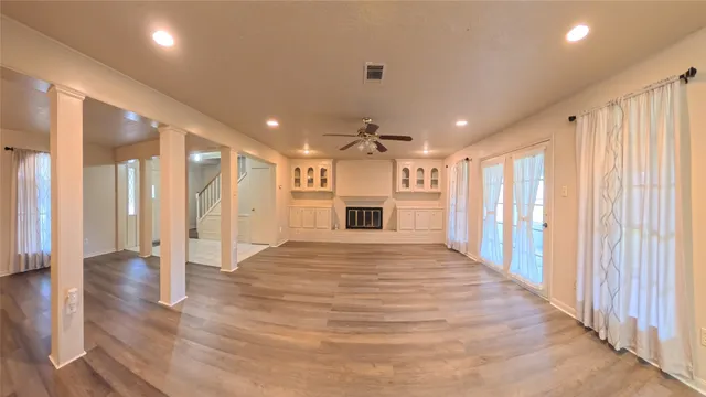 a view of a hallway with wooden floor and staircase