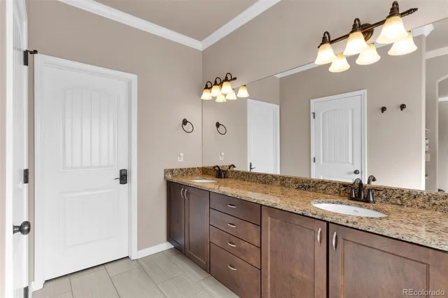 a bathroom with a granite countertop double vanity sink and a mirror
