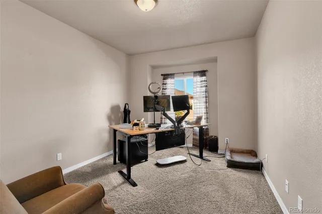 a view of a workspace with furniture and a window