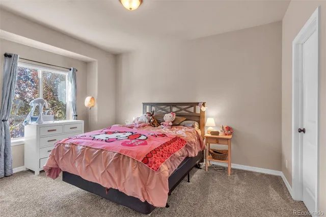 a bedroom with a bed and large windows