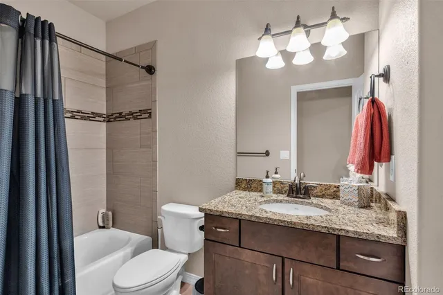 a bathroom with a granite countertop sink toilet and shower