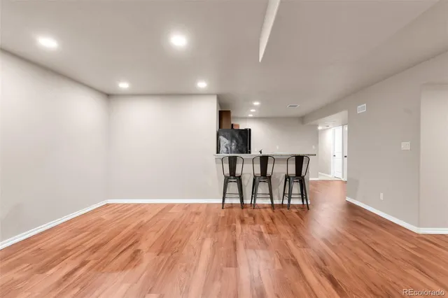 a view of a room with wooden floor kitchen table and chairs