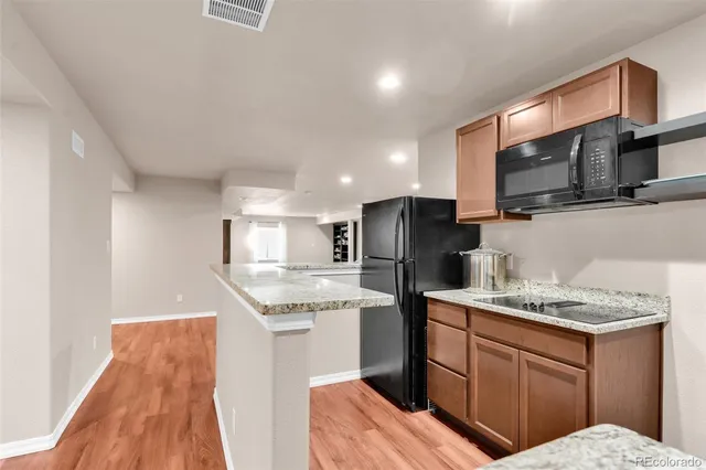 a kitchen with stainless steel appliances granite countertop a sink refrigerator and microwave