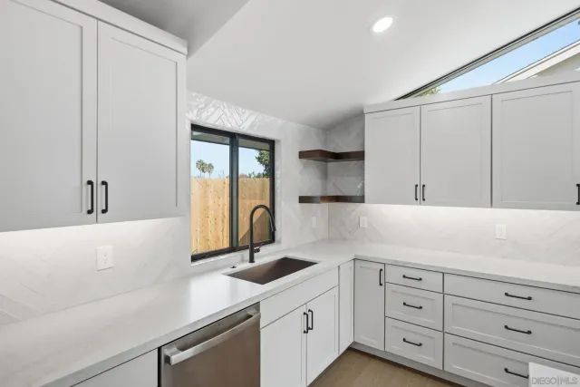 a kitchen with stainless steel appliances a stove a sink a center island and a refrigerator