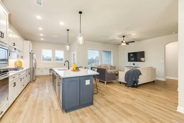 a large kitchen with stainless steel appliances kitchen island granite countertop a large island in the center