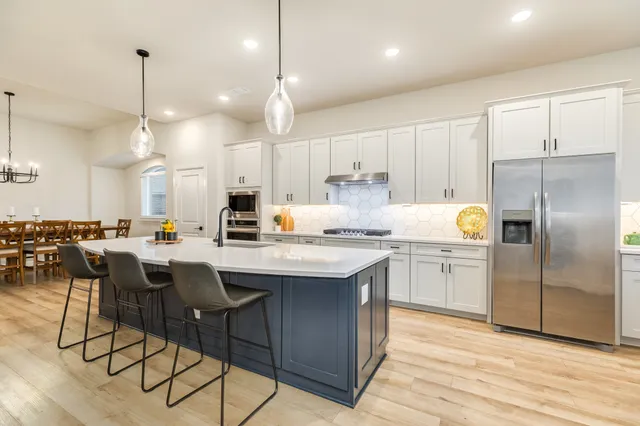 a kitchen with white cabinets and appliances