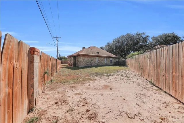 a view of a house with backyard and tree