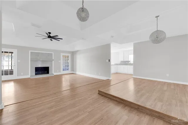 a view of an empty room with a fireplace and a window