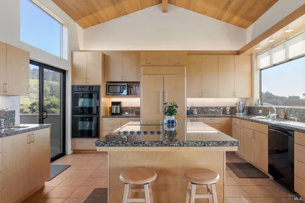 a kitchen with stainless steel appliances granite countertop a sink dishwasher and cabinets with wooden floor