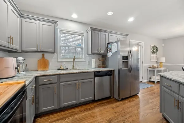 a kitchen with stainless steel appliances granite countertop a refrigerator a sink a stove and island