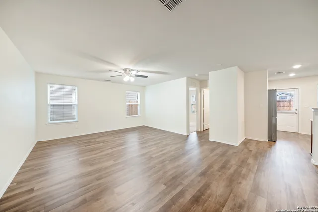 a view of an empty room with wooden floor