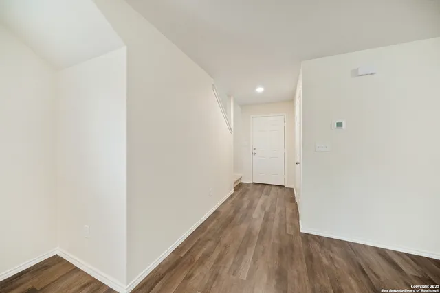 a view of a room with wooden floor