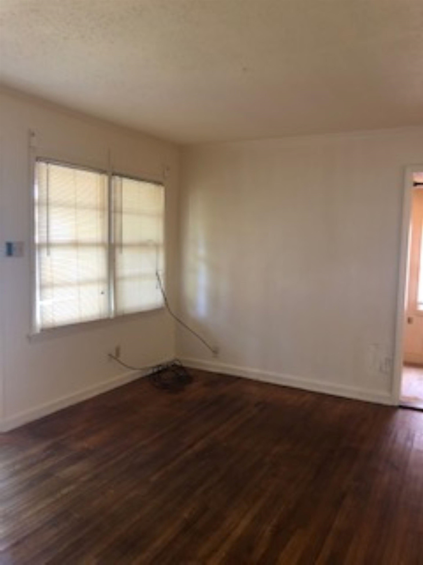 1048 Avon Road Memphis, TN 38122 - Photo 4 of 10 an empty room with wooden floor and windows