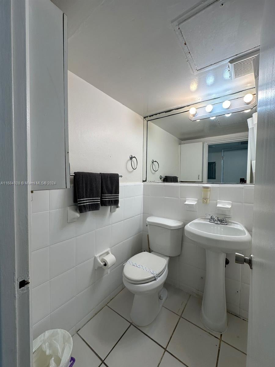 6345 Collins Avenue, Unit 535 Miami Beach, FL 33141 - Photo 8 of 8 a bathroom with a toilet a sink and mirror