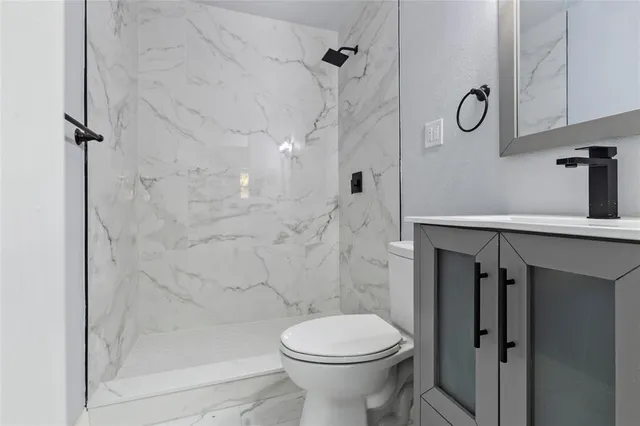 a bathroom with a toilet sink and shower