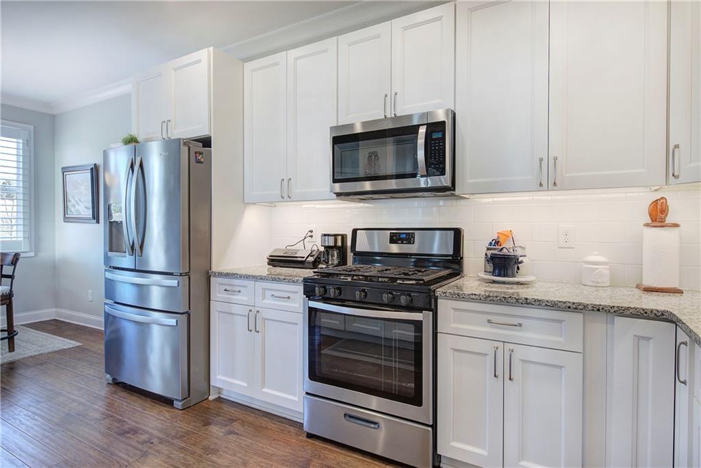 20 Encore Lane Cartersville, GA 30120 - Photo 22 of 44 a kitchen with stainless steel appliances white cabinets a stove a microwave and a refrigerator