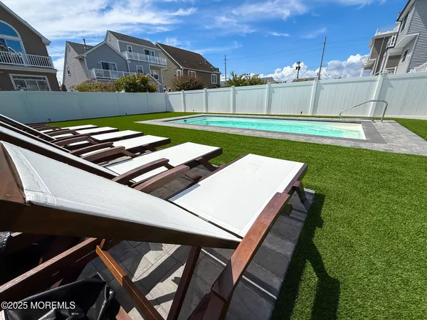 a view of a backyard with a grill and a lawn chairs