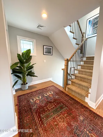 a view of a hallway with wooden floor and stairs