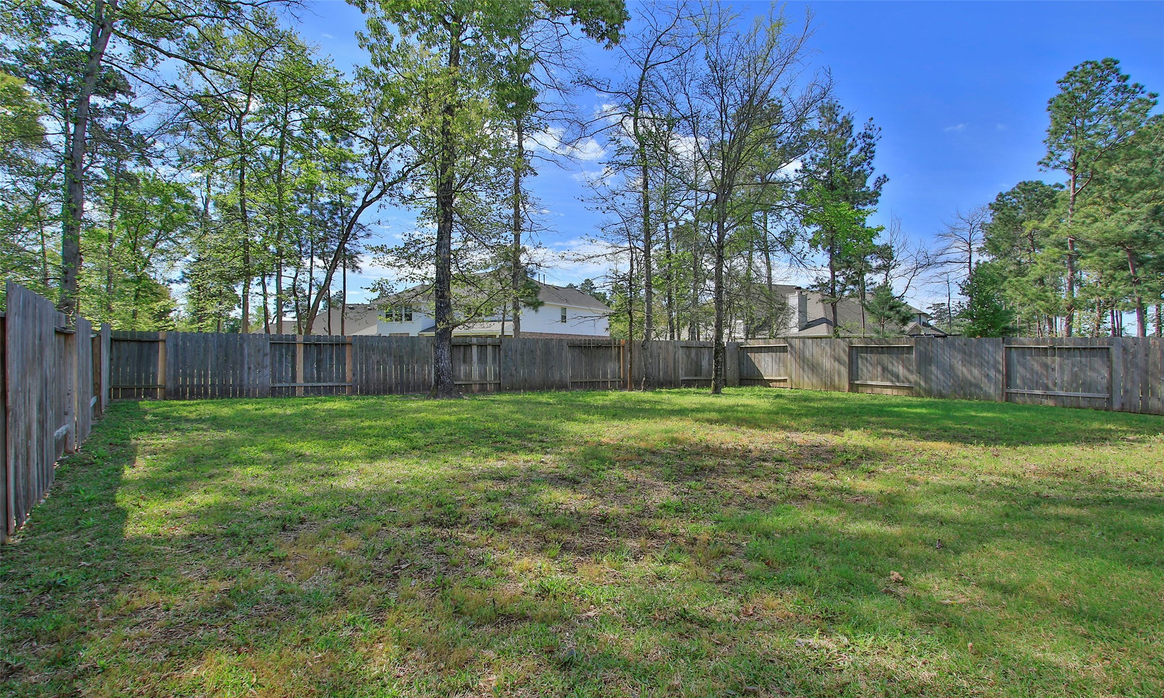 14120 Sand Ridge Court Conroe, TX 77384 - Photo 43 of 43 a view of a backyard with large trees and wooden fence