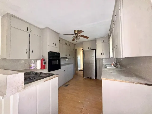 a kitchen with refrigerator a stove and a sink