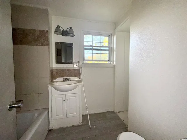 a bathroom with a sink a toilet and window
