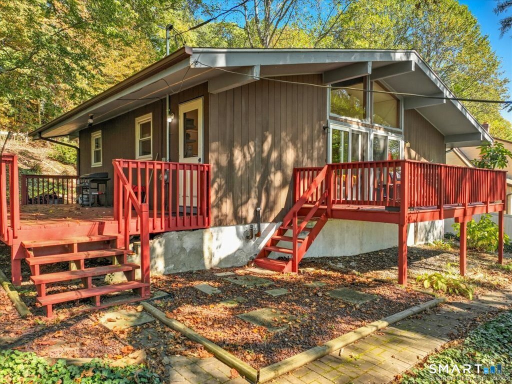 a view of a small house with yard and sitting area
