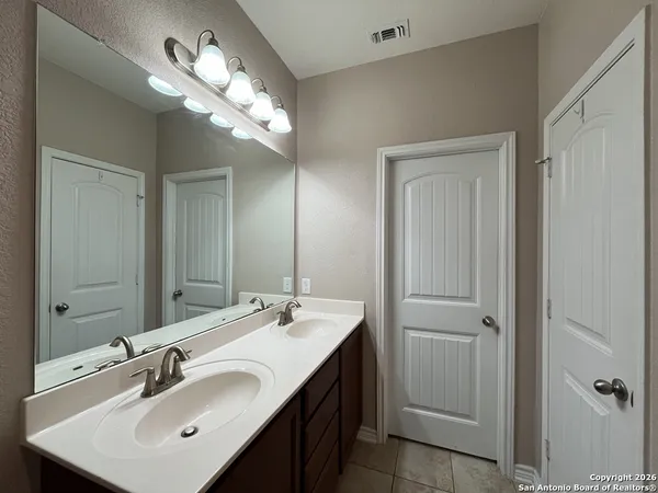 a bathroom with a sink a light fixture and a mirror