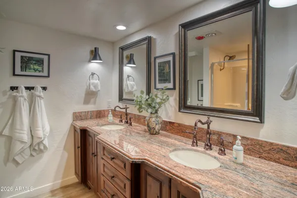 a bathroom with a granite countertop double vanity sinks and a mirror