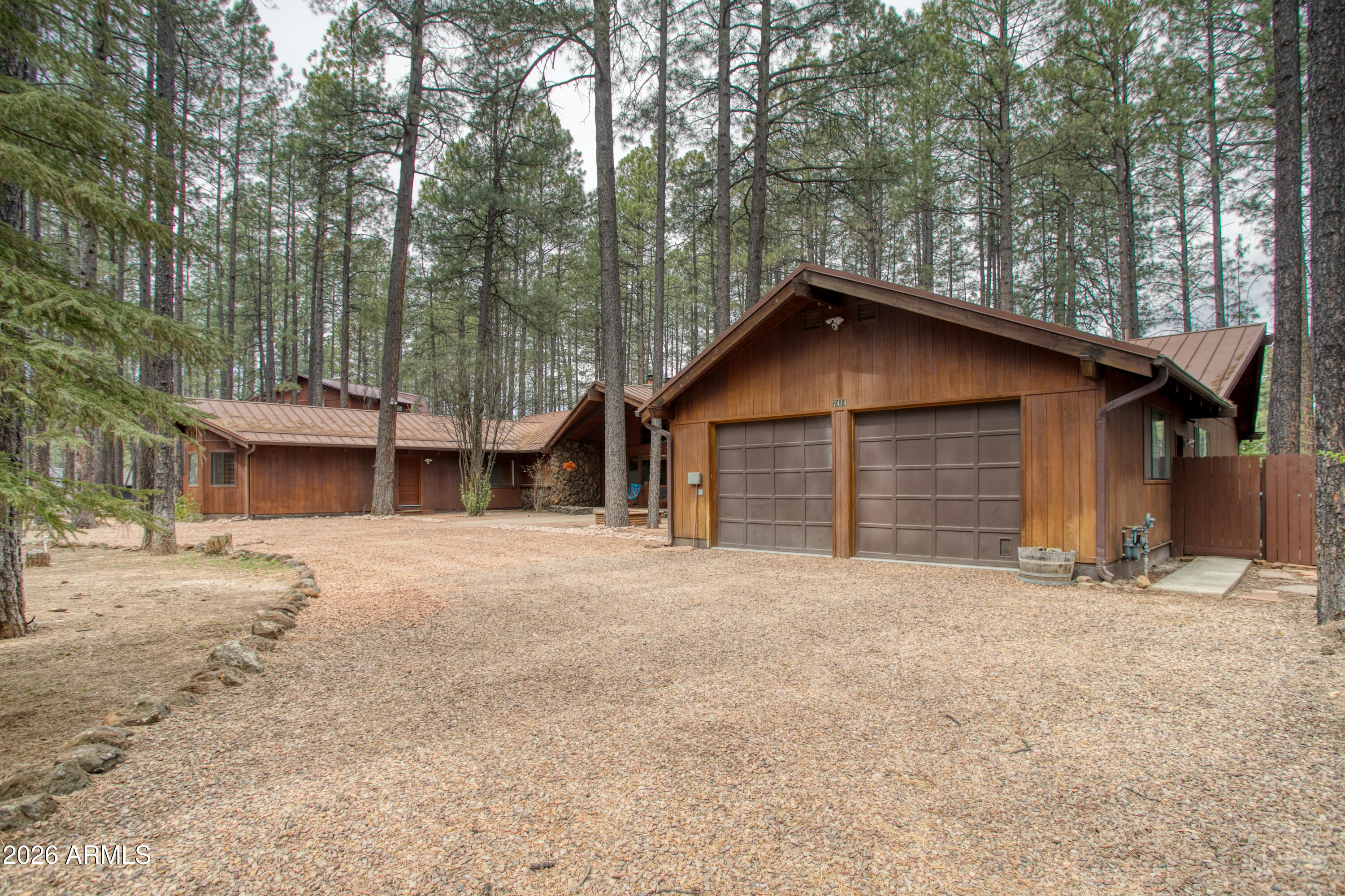 7414 Geronimo Road Pinetop, AZ 85935 - Photo 4 of 67 a front view of a house with a yard and garage