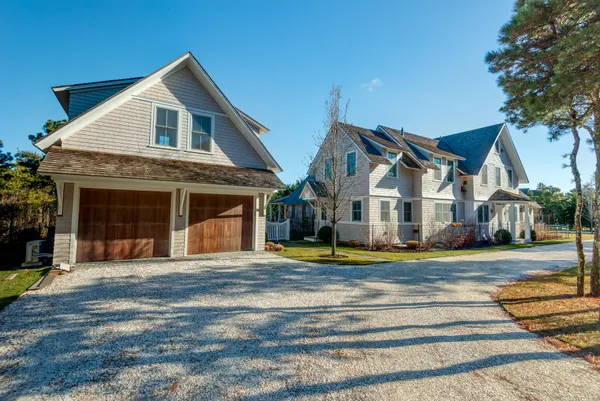 a view of a white house with a yard and plants