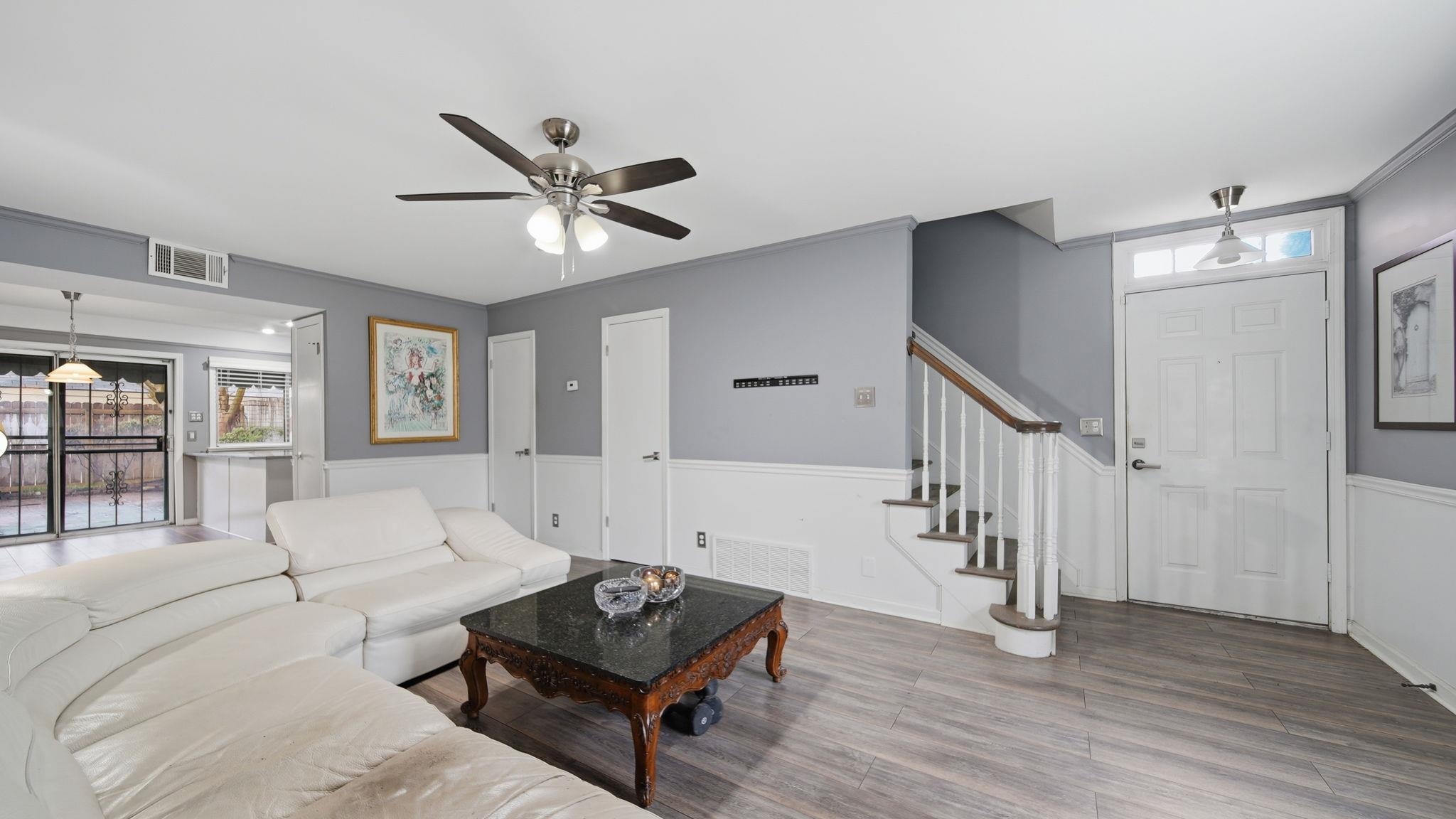 5866 Roxbury Drive, Unit 5866 Memphis, TN 38119 - Photo 4 of 20 Spacious living area featuring wood-finish flooring, wainscoting, and a ceiling fan with integrated lighting