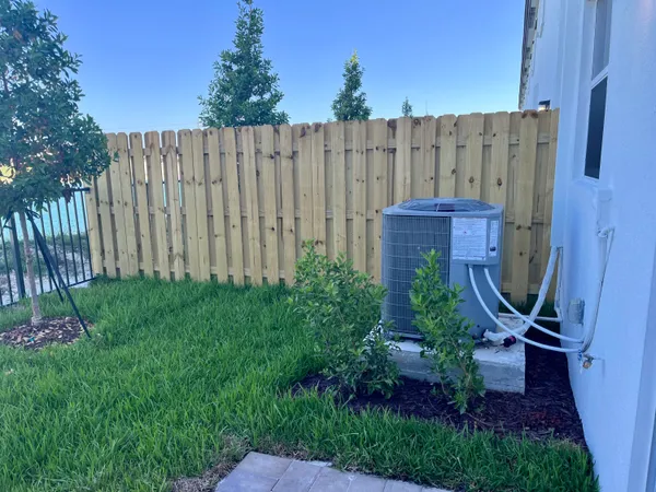 a view of a backyard with potted plants and a bench