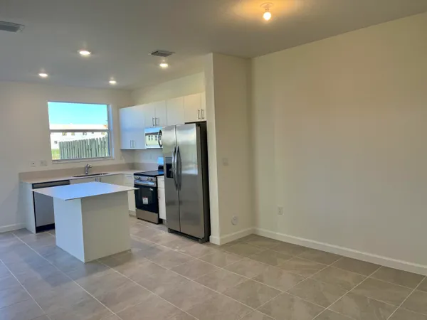 a kitchen with kitchen island a sink stainless steel appliances and window