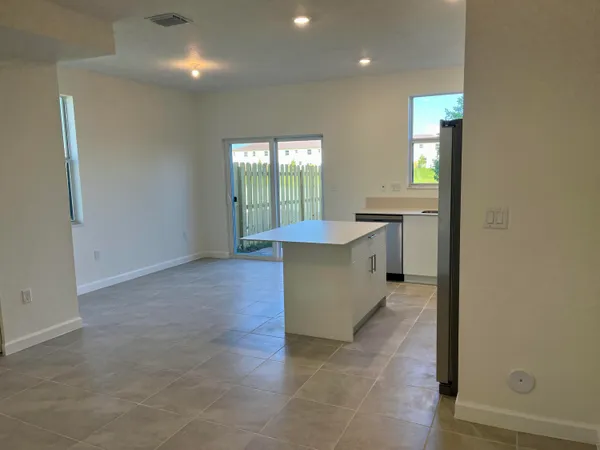 a kitchen with stainless steel appliances a refrigerator a sink a stove top oven a counter space and cabinets