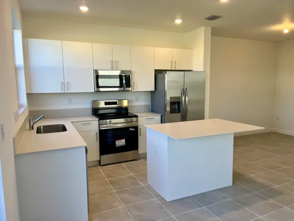 a kitchen with stainless steel appliances a refrigerator and a stove top oven