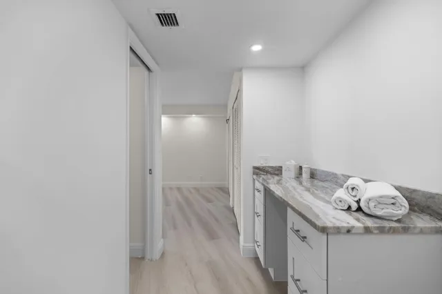 a bathroom with a granite countertop sink and a mirror