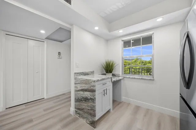 a view of kitchen with stainless steel appliances granite countertop a stove and a refrigerator
