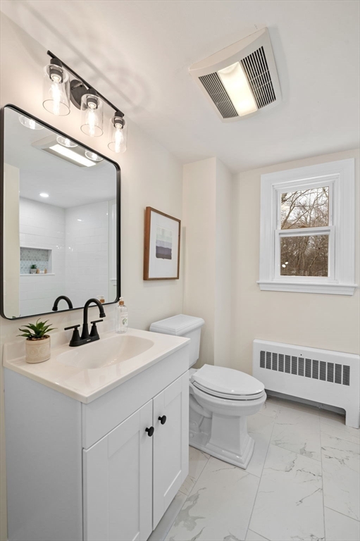 98 John Carver Road Reading, MA 01867 - Photo 20 of 40 a bathroom with a double vanity sink a toilet and a mirror